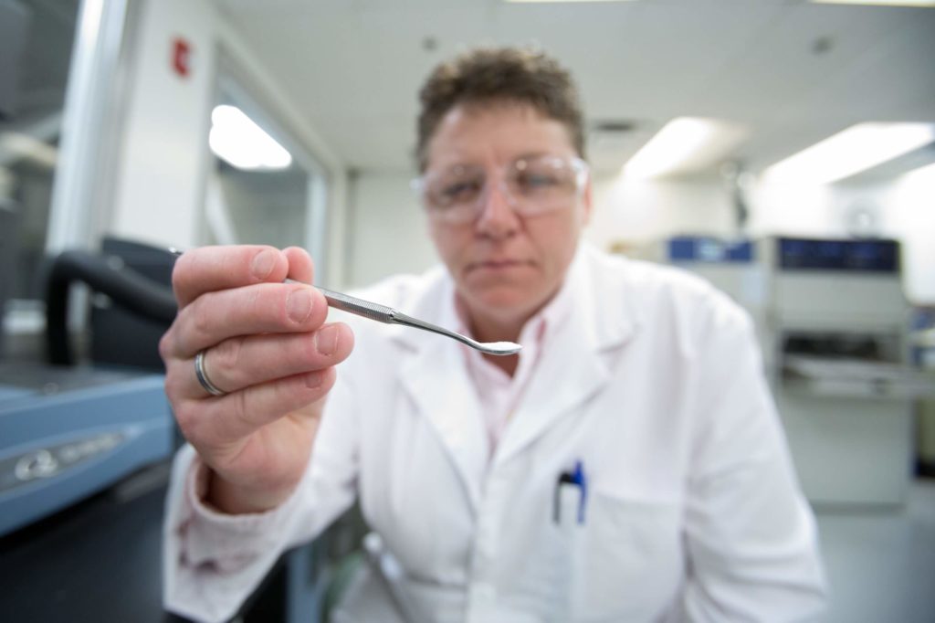 Scientist holding spoon of PVC compound